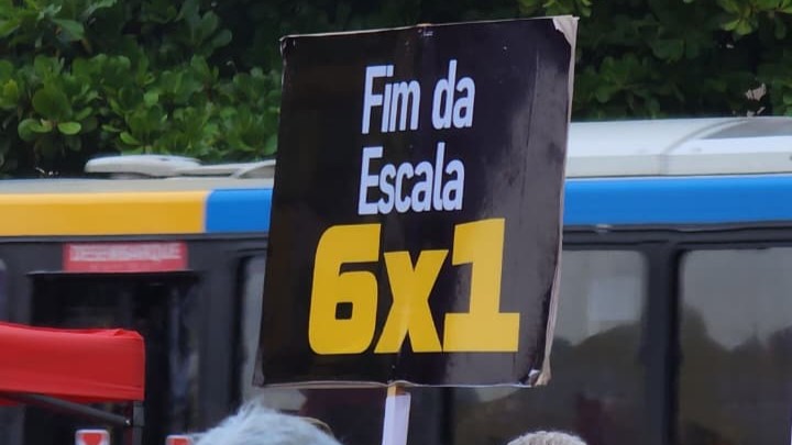 Cartaz com a frase “Fim da escala 6x1” durante ato do Dia do Trabalhador em Copacabana.
