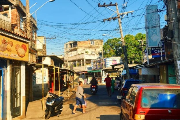 Pessoas andando pela Estrada de Manguinhos em um dia de calor forte