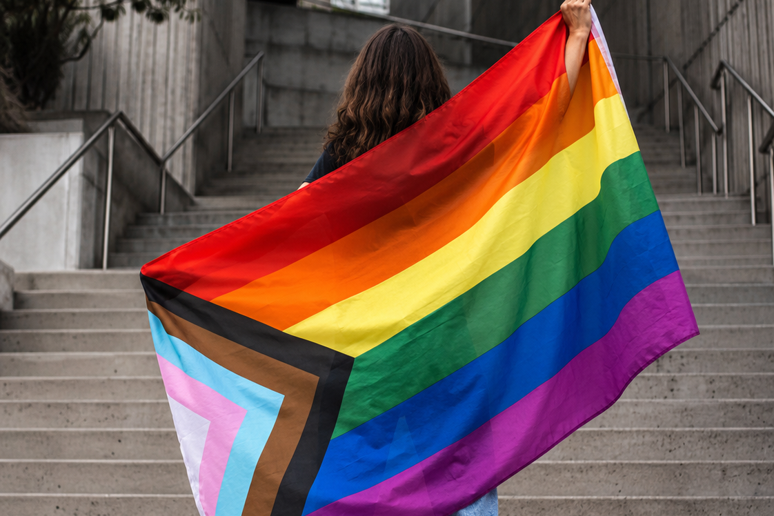 Pessoa segurando bandeira LGBTQIAPN+