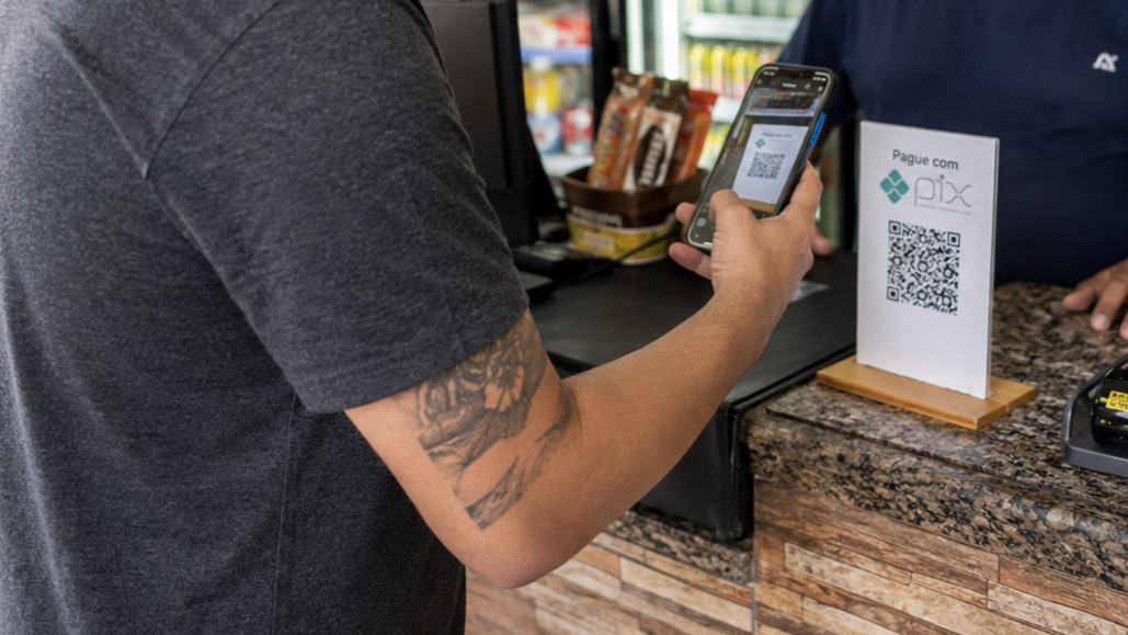 Cliente escaneando QR Code para pagar com Pix em mercadinho de bairro